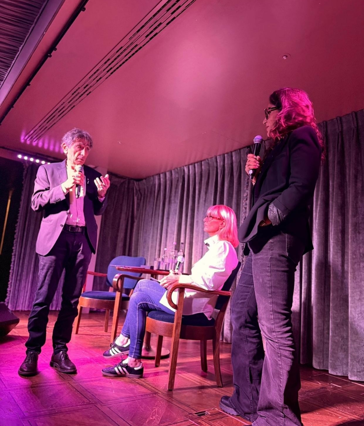 Dr Gabor Maté, Rosemary Reed and a guest holding microphones on stage at the Prime Time Reset conversation