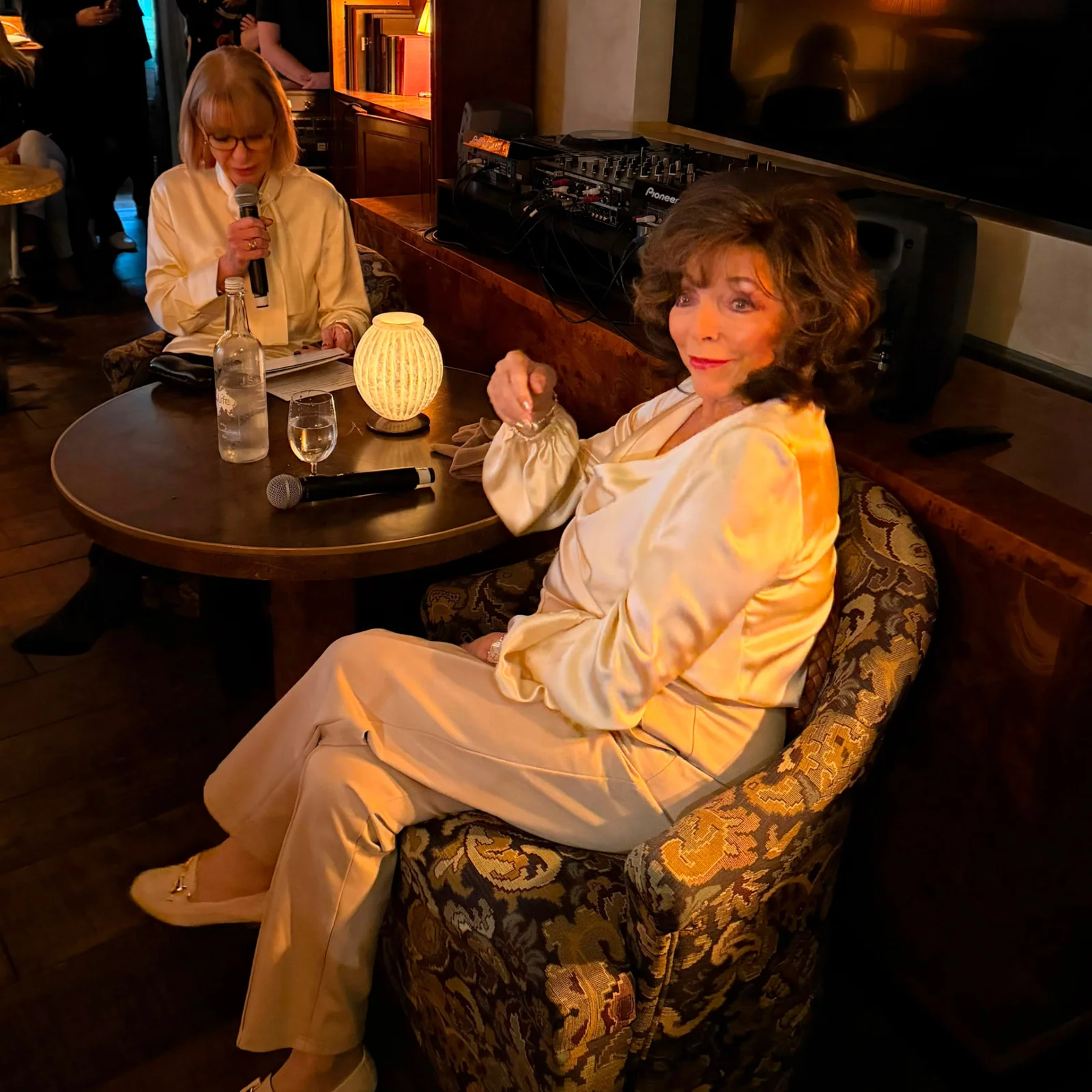 Two guests in cream satin outfits in conversation at a Prime Time Reset live event