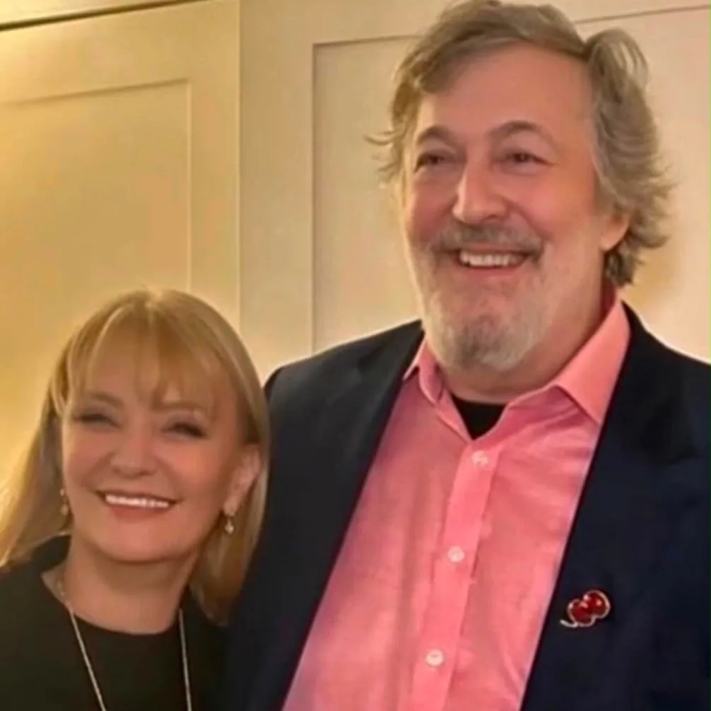 Two guests smiling together in front of a paneled wall at a Prime Time Reset live event