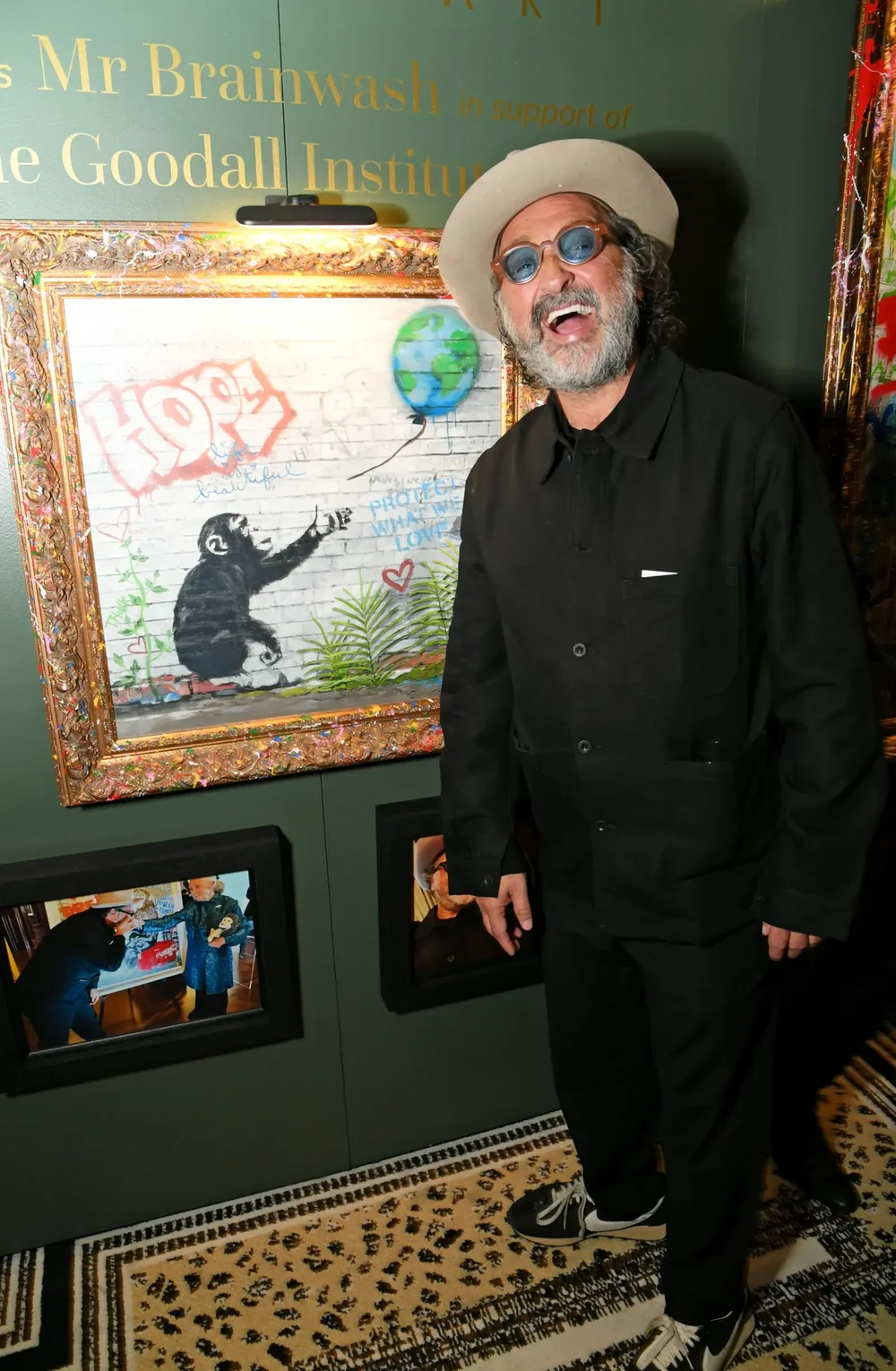The artist Mr Brainwash beside his exhibited painting at The Hope Gala