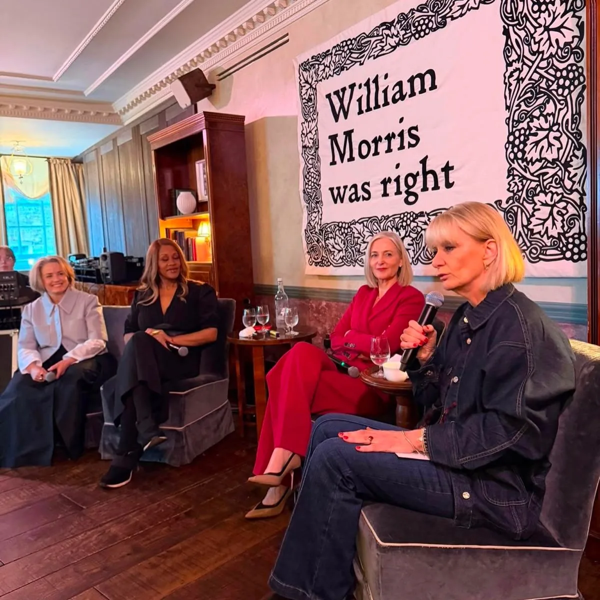 Guests seated on a panel beneath a William Morris was right banner at a Prime Time Reset live event