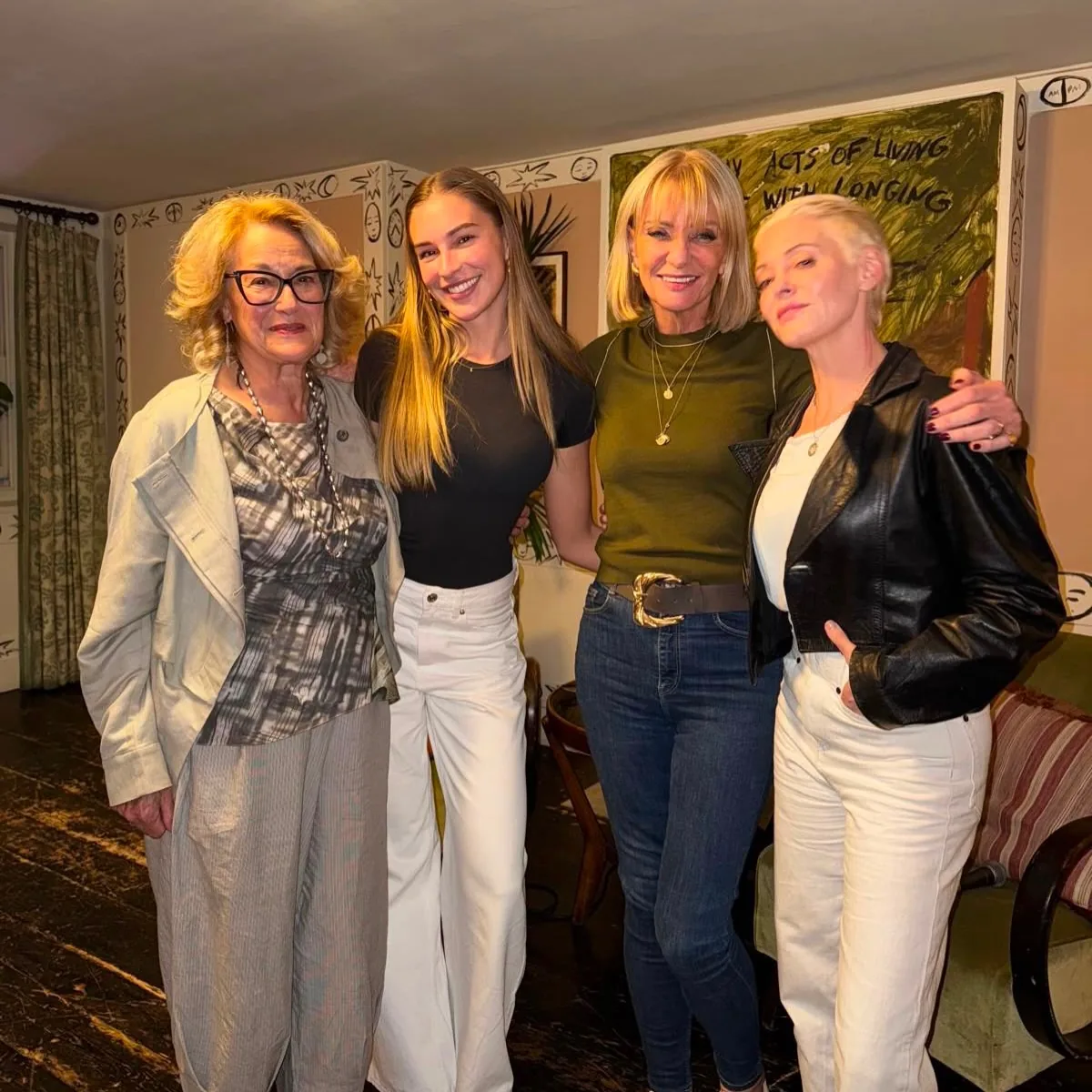 Four guests posing together beneath a wall mural reading Acts of Living with Longing at a Prime Time Reset live event