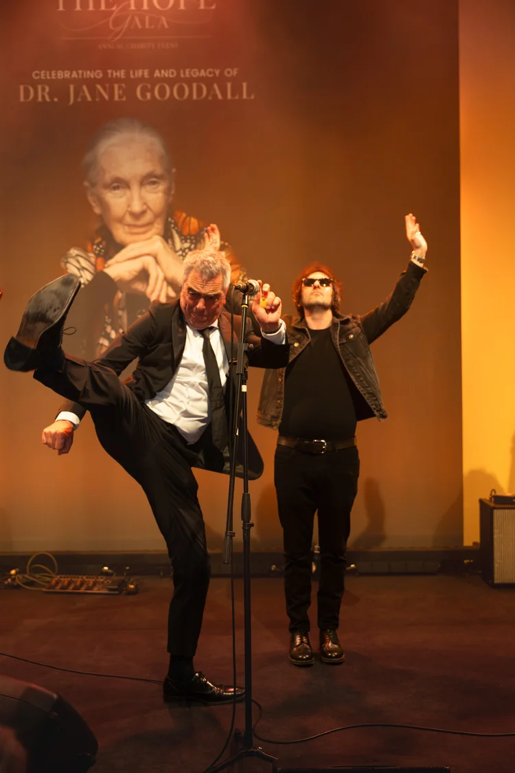 Performers on the stage of The Hope Gala in front of the backdrop portrait of Dr Jane Goodall