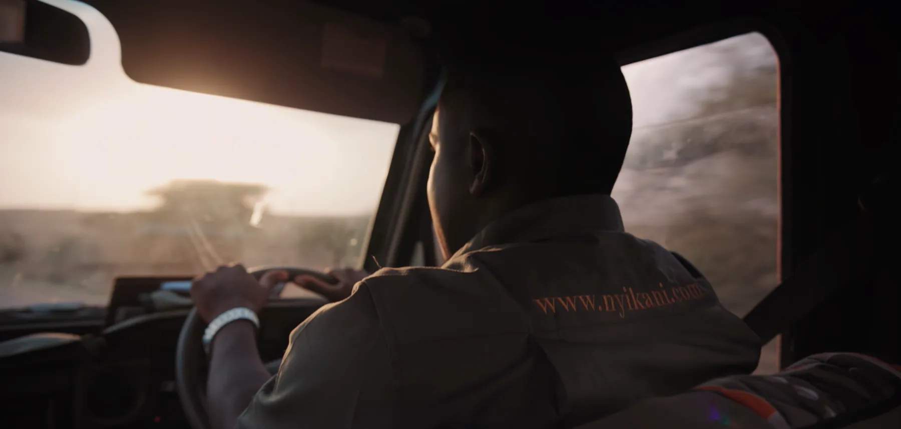 A Nyikani safari guide driving through the Kenyan bush at sunset
